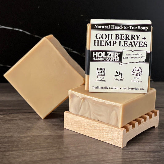 Goji Berry + Hemp Leaves soap bar with packaging on a hardwood soap dish